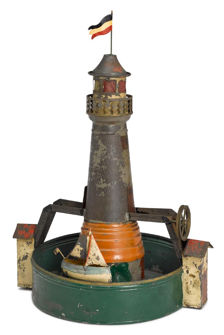 Painted tin lighthouse steam toy accessory: Painted tin lighthouse steam toy accessory, with a sailboat that rotates around the moat, 15 1/2'' h. Pictured in Morton A. Hirschberg Steam Toys - A Symphony in Motion, page 67. Provenance: Morton A.