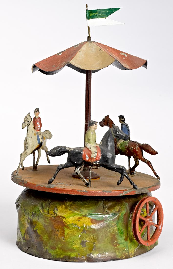 Carette carousel steam toy accessory: Carette painted tin carousel steam toy accessory, with three horse and riders, 9 1/2'' h. Pictured in Morton A. Hirschberg Steam Toys - A Symphony in Motion, page 91. Provenance: Perelman Toy Museum; 