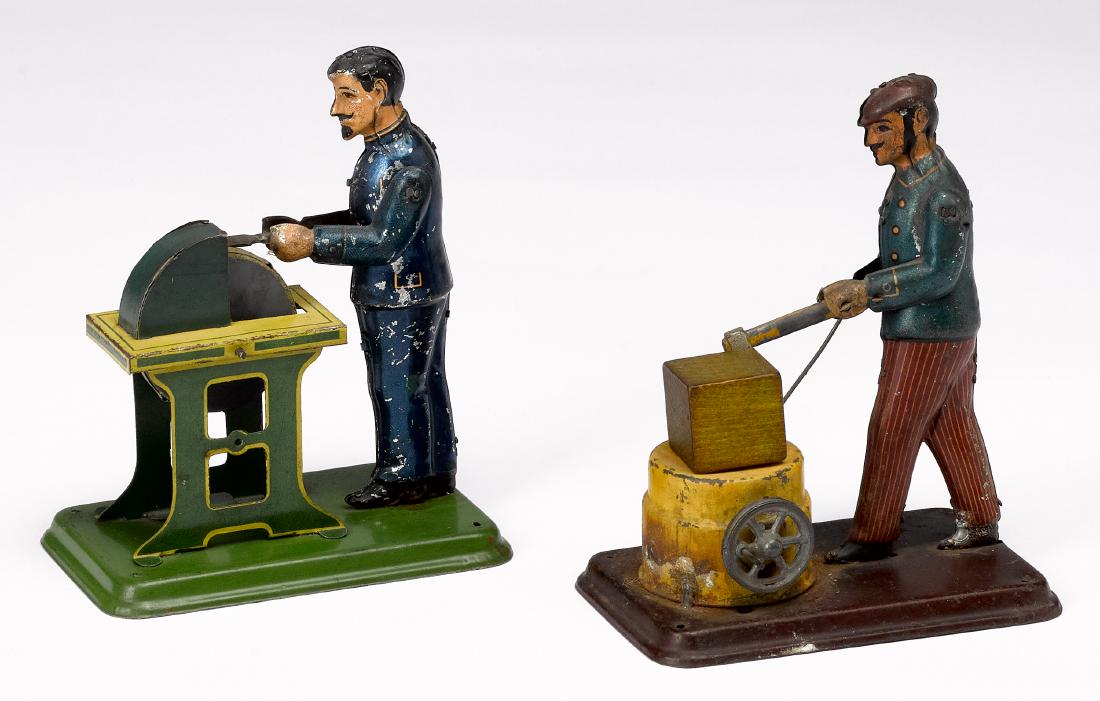 Two Carette workmen steam toy accessories: Two Carette tin lithograph workmen steam toy accessories, to include a grinder and a woodsman, 5 1/2'' h. Pictured in Morton A. Hirschberg Steam Toys - A Symphony in Motion, page 74 and 75. Provenance