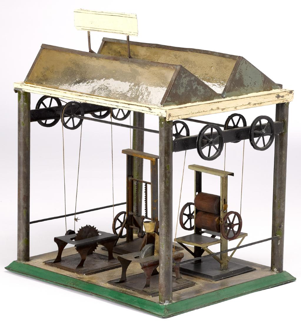 Painted tin factory steam toy accessory: Painted tin factory steam toy accessory, probably Bing, with vertical saw, circular saw, grinding wheel, and a press, all under a canopy, 14'' h., 12'' w. Pictured in Morton A. Hirschberg Steam Toys -