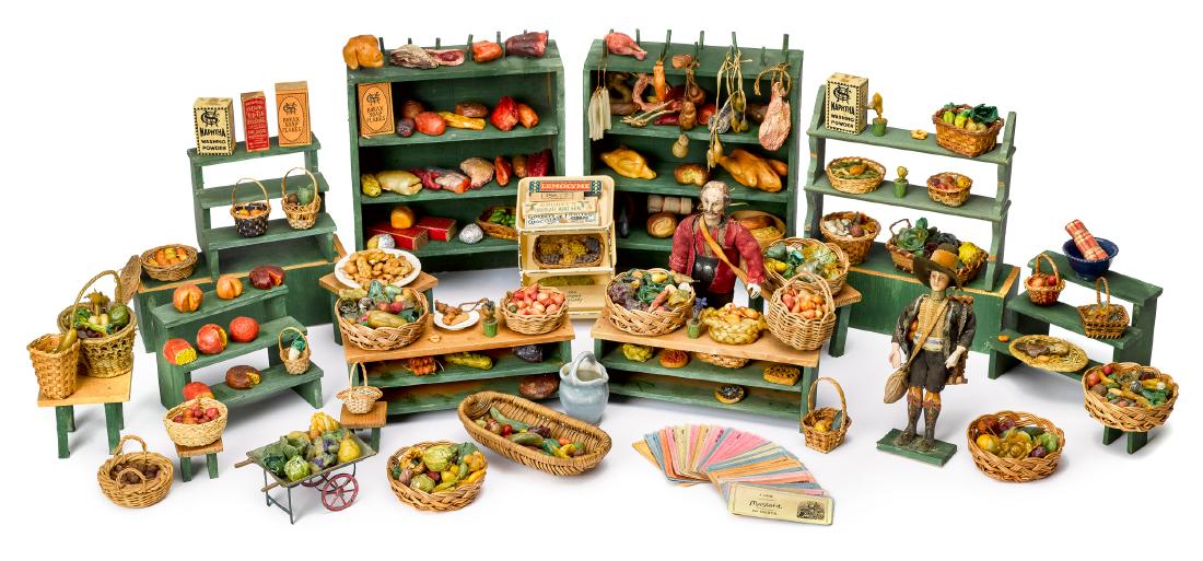 Early European grocery market diorama: Early European grocery market diorama, with painted wood shelves, stalls and counters, with a extensive group of molded wax fruit and meats, lithographed grocery cards, and two carved wood dolls, one 