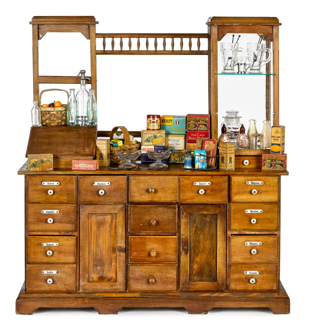 German child's-size grocery counter: German child's-size grocery counter, with German signage porcelain drawer labels and glass shelved towers, together with various products, 34'' h., 30'' w.