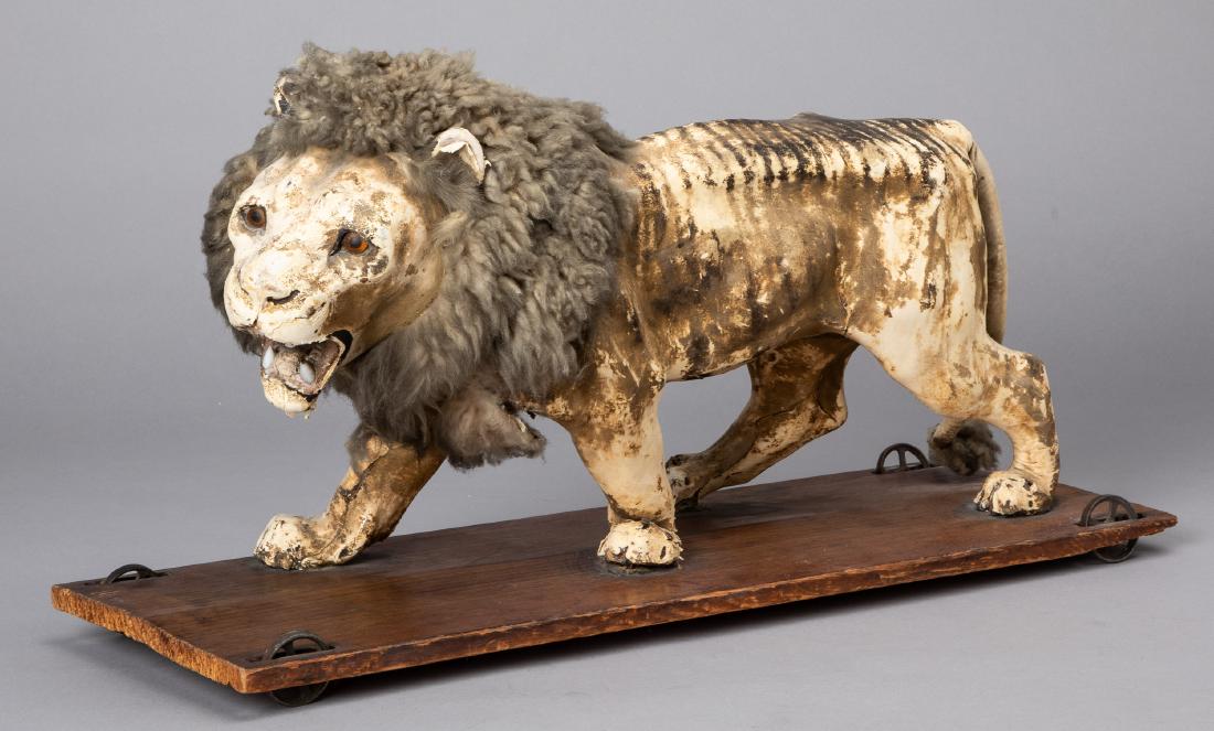 Composition lion pull toy: Composition lion pull toy, on a wooden platform, 21 1/2'' l.