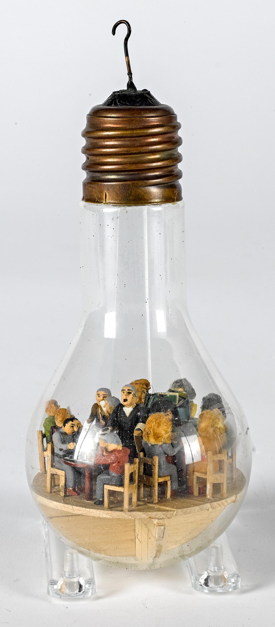 Carved and painted diorama in a lightbulb: Carved and painted diorama in a light bulb, with an intricately carved and detailed scene of diners seated at tables with a waiter, overall height - 8''.