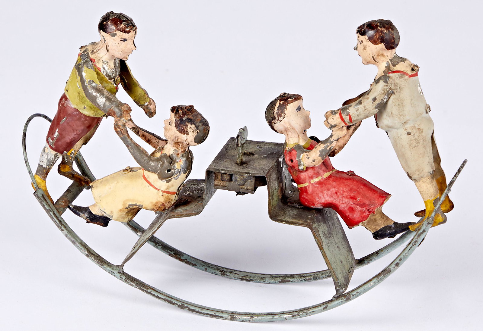 Early painted tin clockwork seesaw toy: Early painted tin clockwork seesaw toy, with a boy and girl on opposing sides, 9 1/2'' w.