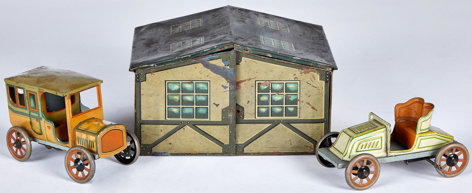 Bing tin lithograph garage and cars: Bing tin lithograph garage and cars, to include a wind-up limousine and open roadster, garage - 6 1/2'' l.