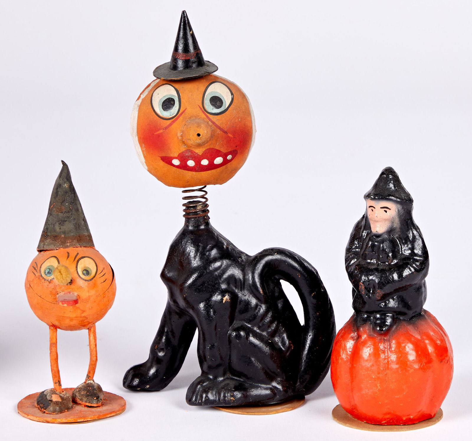 Three Halloween candy containers: Three Halloween candy containers, to include a German Jack-o-lantern cat figure with spring head, 9'' h., a pumpkin man with tongue sticking out, and a US Paper Pulp witch on a pumpkin.