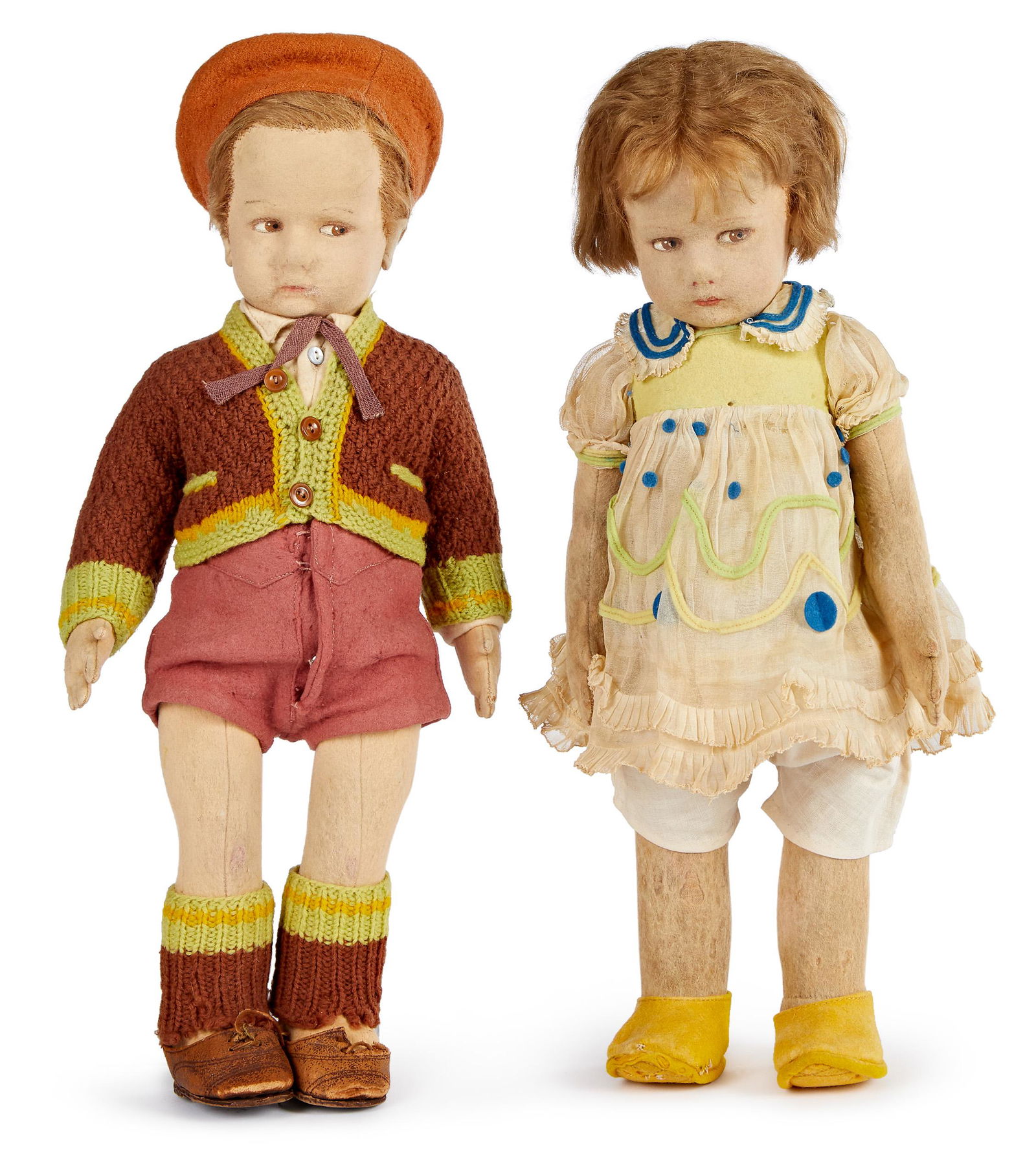 Lenci boy and girl felt dolls: Lenci boy and girl felt dolls, both with hollow torsos, painted side glancing almond shaped eyes and closed mouths, the boy dressed in school boy sweater with matching socks and leather shoes, the gir