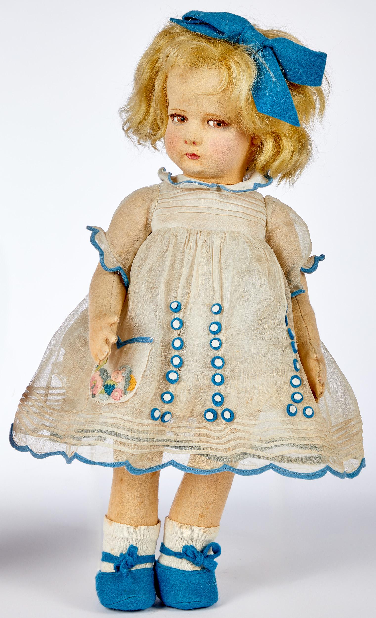 Lenci girl felt doll with blue bow: Lenci girl felt doll with blue bow, with hollow torso, painted almond shaped side glancing eyes and closed mouth, with blonde mohair wig, an organdy dress with blue felt decoration, stamped Lenci on b