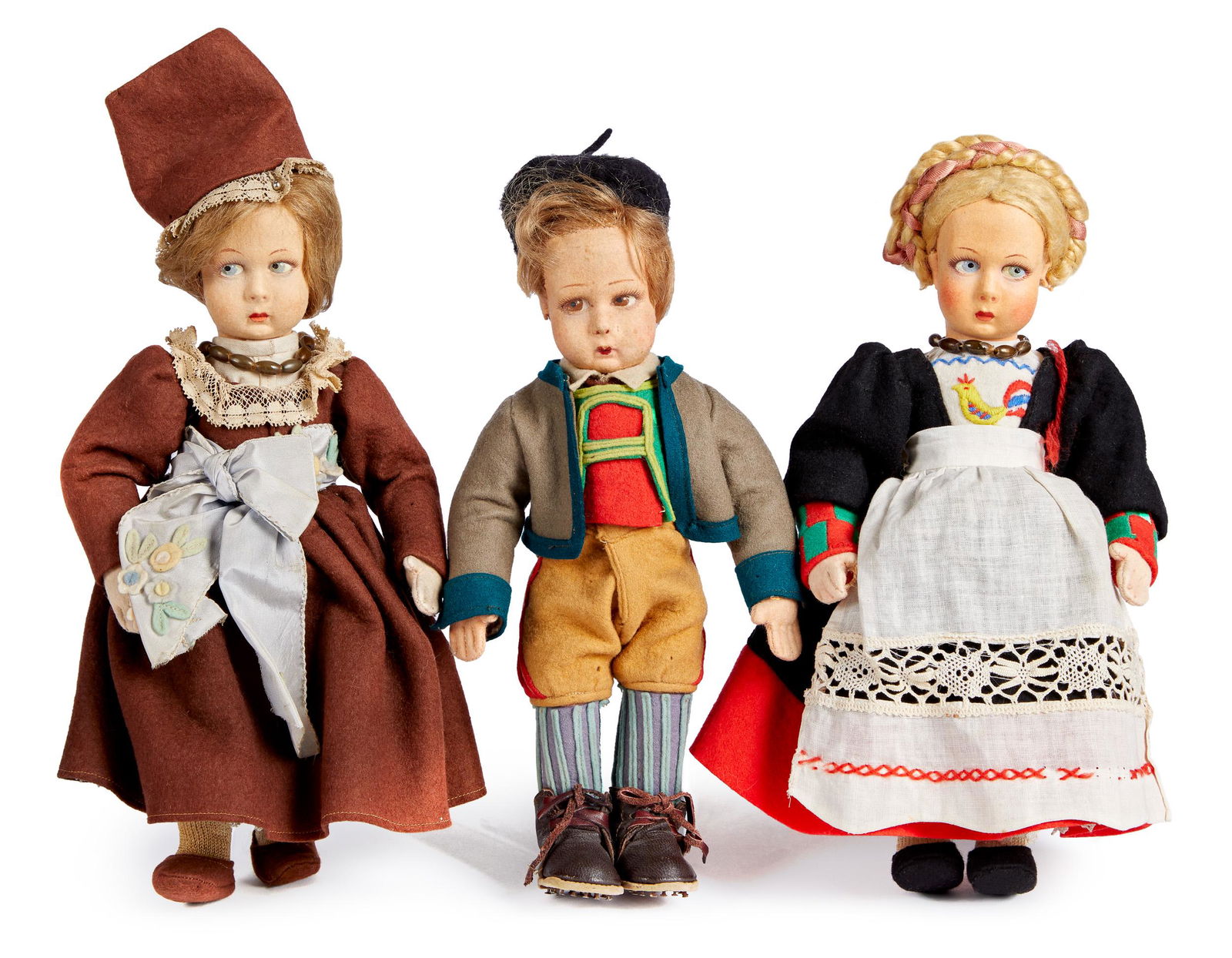 Three Lenci felt dolls in regional costumes: Three Lenci felt dolls in regional costumes, with cloth stuffed torsos, painted side glancing eyes and mitten type hands with defined fingers, the child with the blonde braid retains a Lenci ribbon an