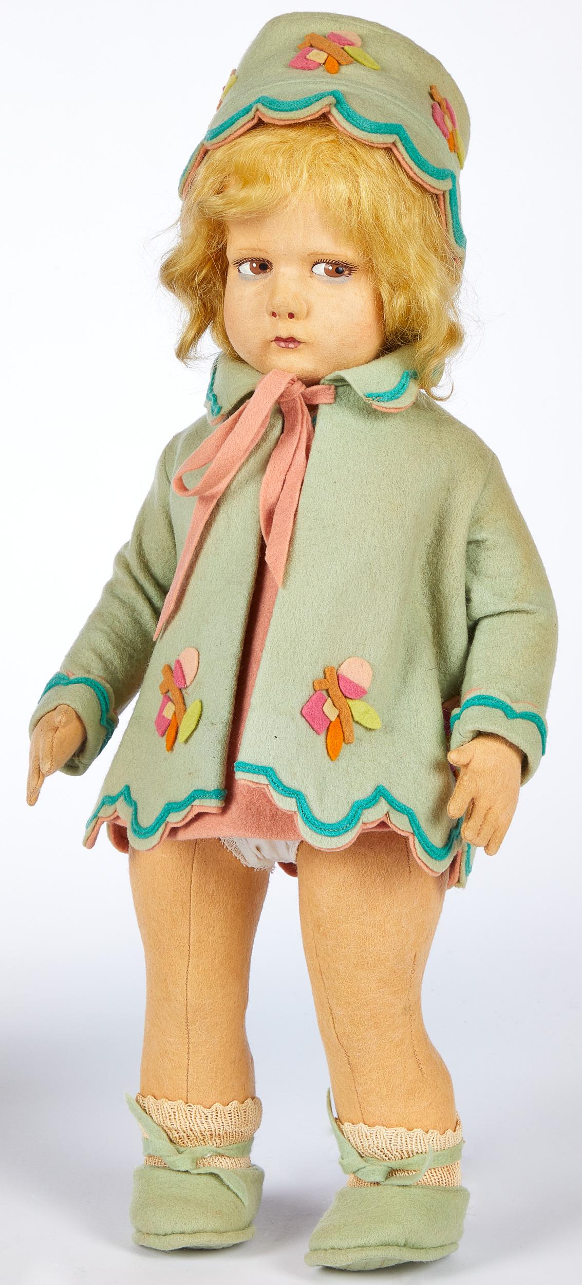 Lenci girl felt doll: Lenci girl felt doll, with hollow torso, swivel head, painted side glancing eyes with blue under eye shadow, closed mouth in felt costume with matching hat and quilted sole shoes, 17'' h.
