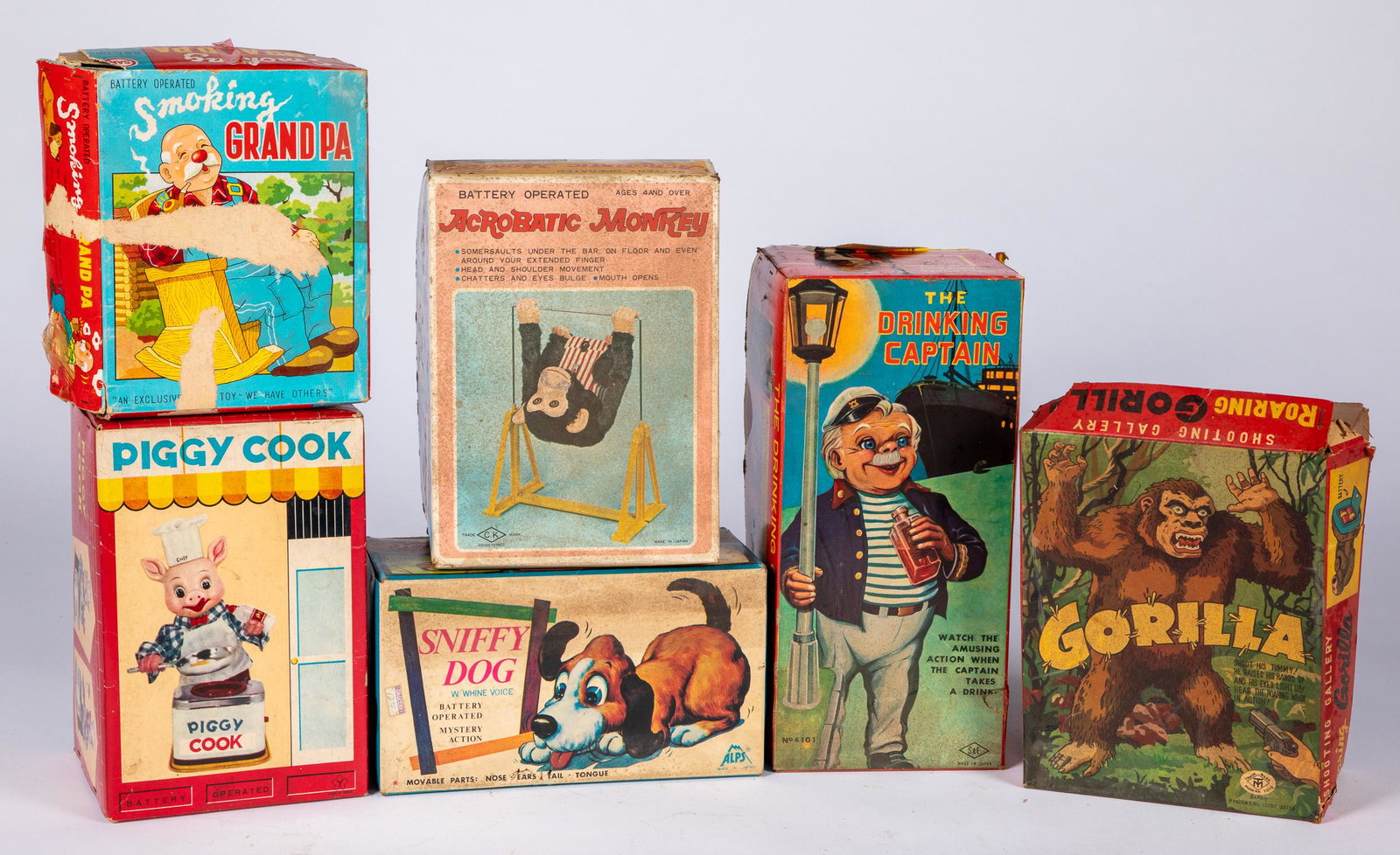 Six battery operated toys: Six battery operated toys, in the original boxes, to includePiggy Cook, Shooting Gallery - Roaring Gorilla, Acrobat Monkey, Sniffy Dog, The Drinking Captain, and Smoking Grandpa.