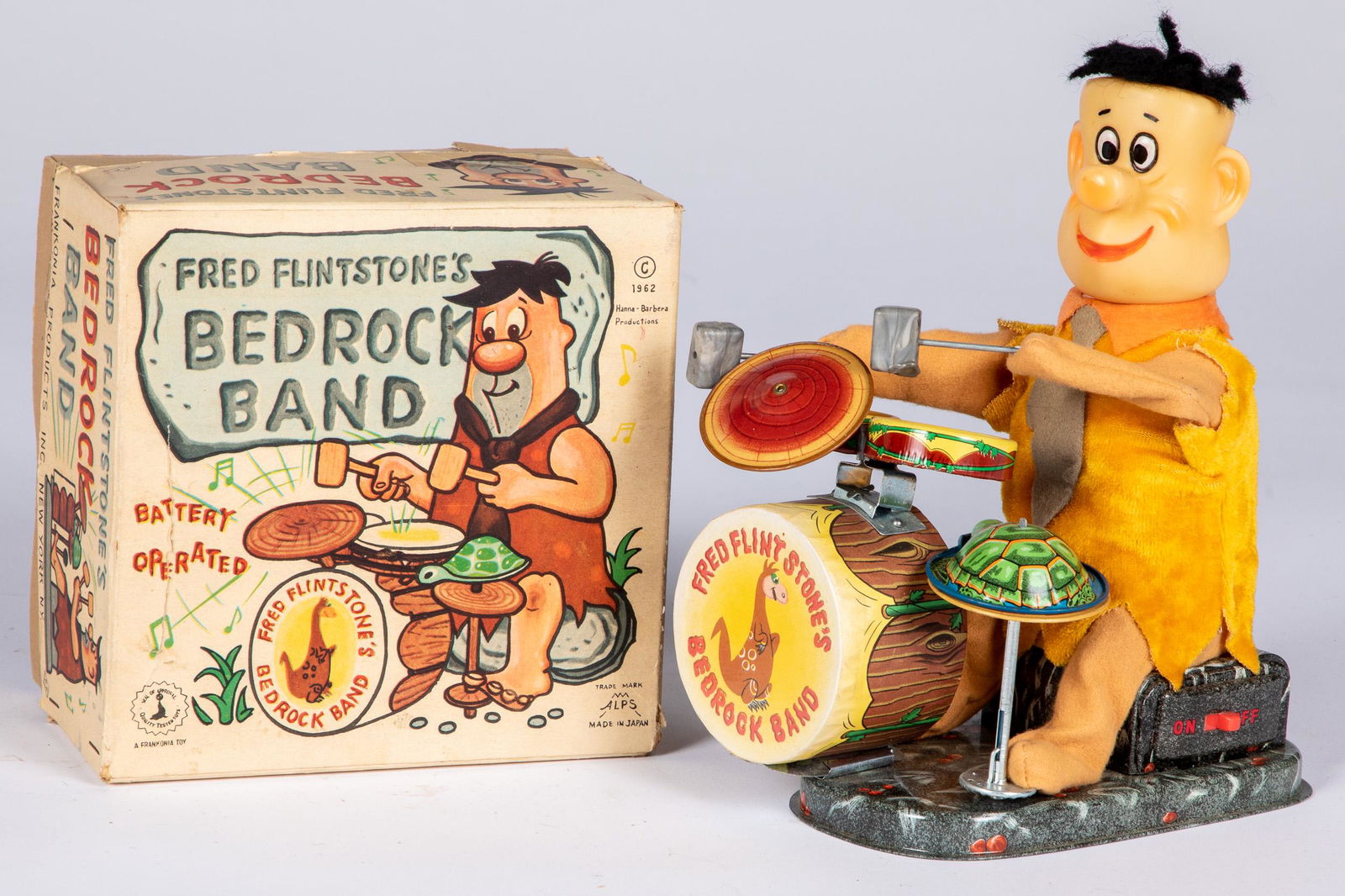 Alps Fred Flintstone: Alps battery operated Fred Flintstone's Bedrock Band, in the original box, 9'' h.