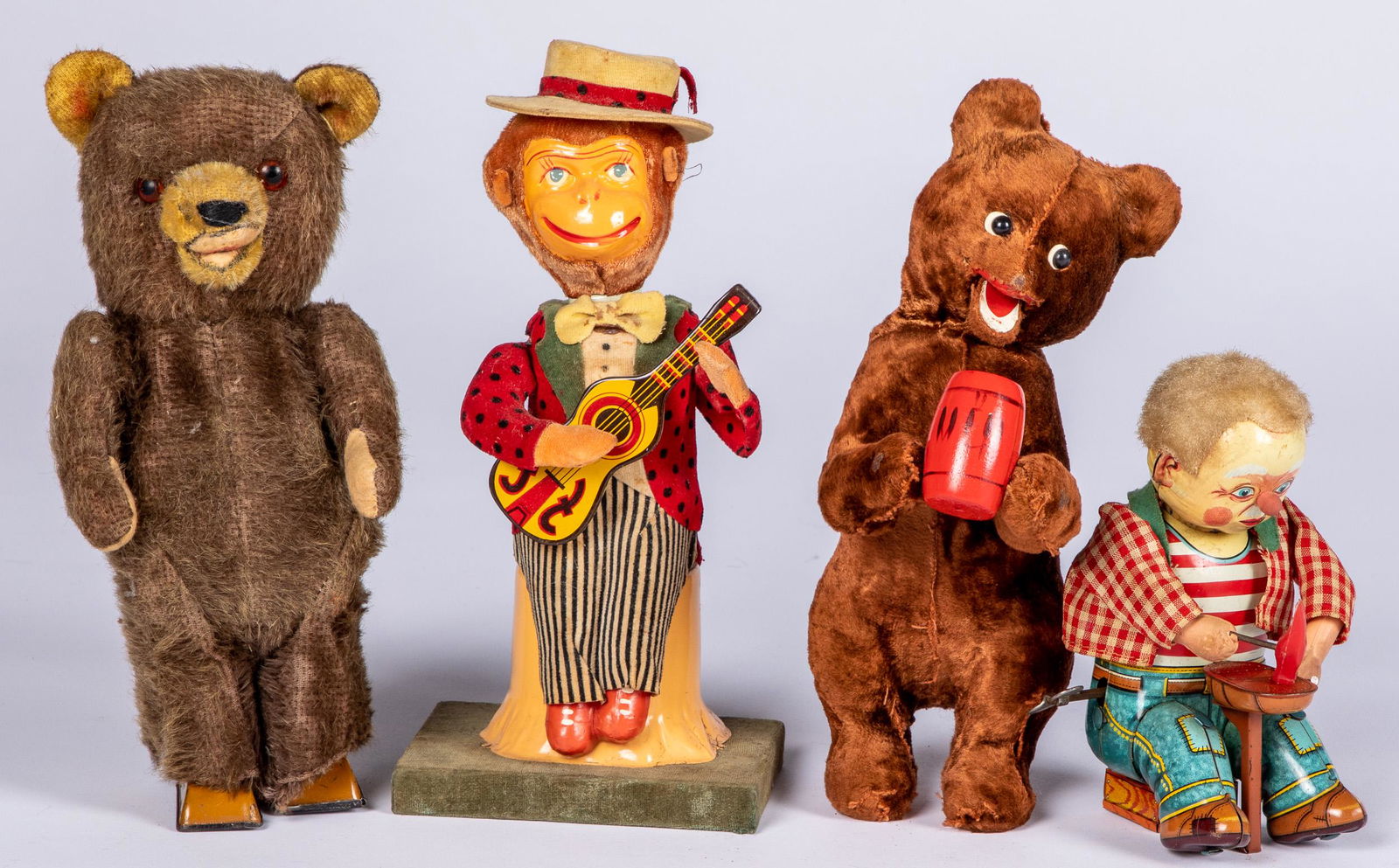 Four wind-up toys: Four wind-up toys, to include a Japanese tin lithograph cobbler, 6'' h., a monkey playing a guitar, a walking bear, and a drinking bear.