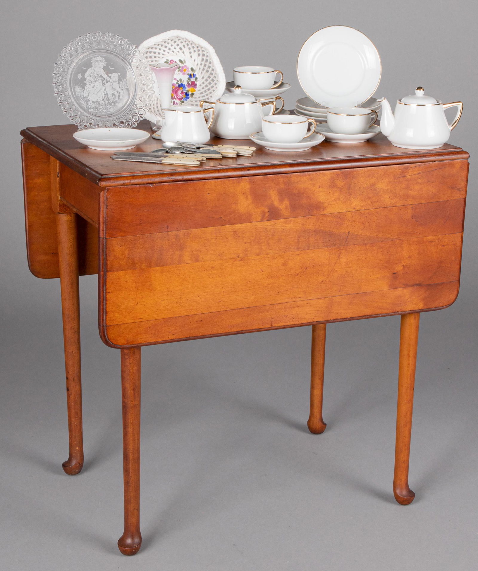Child's cherry drop-leaf table, etc.: Child's cherry drop-leaf table, together with two cane seat chairs and a porcelain tea service, table - 20'' h., 20'' d.