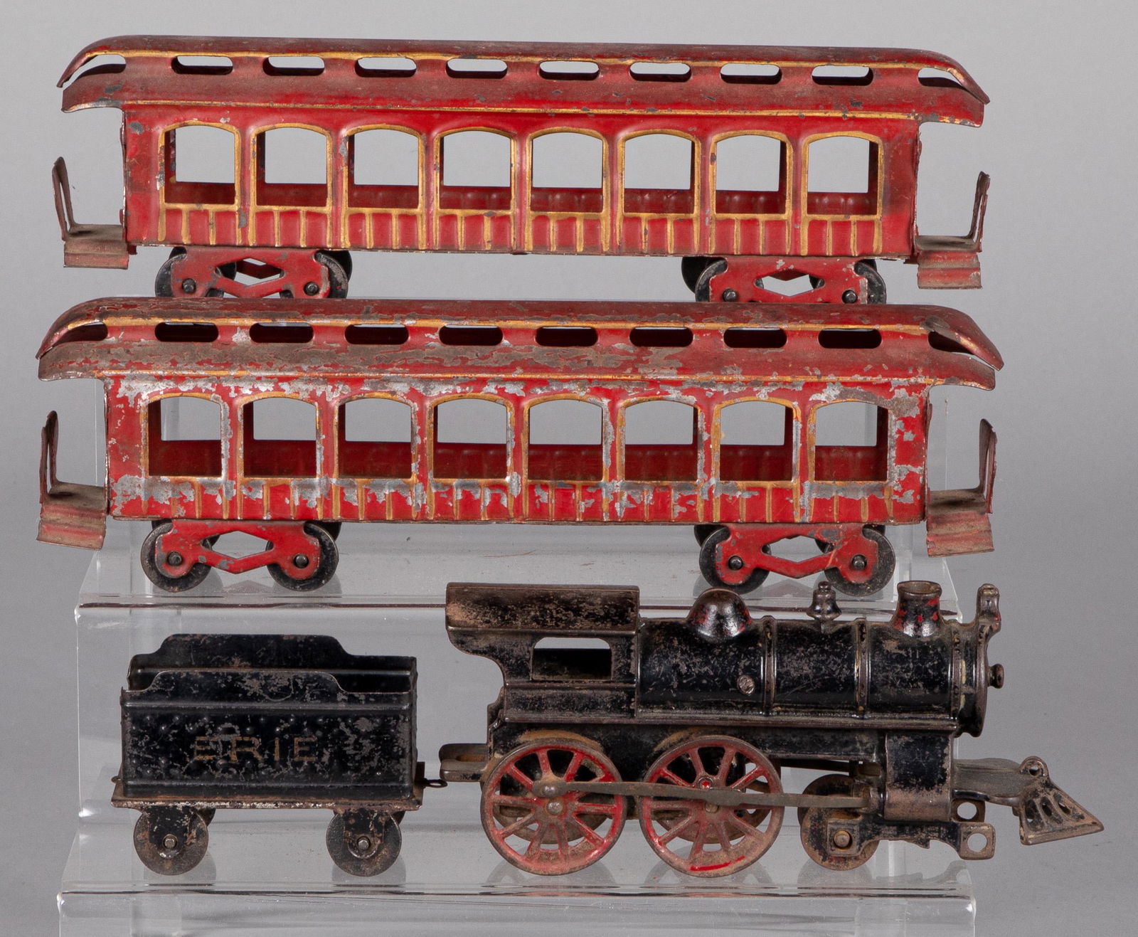 Cast iron and tin passenger train set: Cast iron and tin passenger train set, to include a 4-4-0 locomotive, painted tin Erie tender and two coaches, engine - 9'' l.