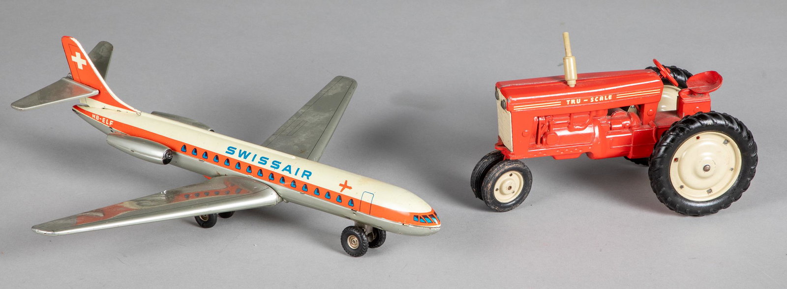 Arnold tin lithograph friction Swiss airplane, et: Arnold tin lithograph friction Swiss Air airplane, 14 1/4'' wingspan, together with a diecast Tru-Scale International tractor, 8 3/4'' l.