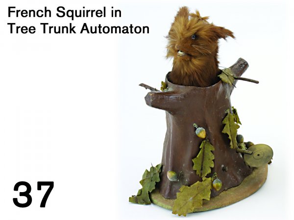 French Squirrel in Tree Trunk Automaton: hide covered animal in paper mache tree trunk decorated with acorns and leaves; accompanied by music, the squirrel moves his mouth, rises and turns in trunk. A fine piece in very nice condition 10" t.