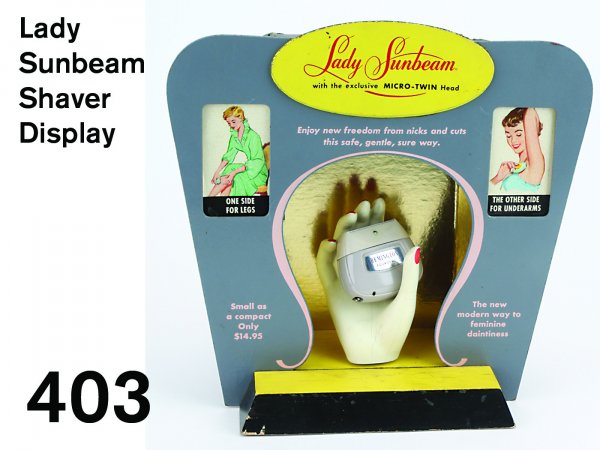 Lady Sunbeam Shaver Display: heavy board electric display, painted composition hand holding Remington Foursome razor turns left and right illuminating the corresponding side; rear has full printed directions and selling features 