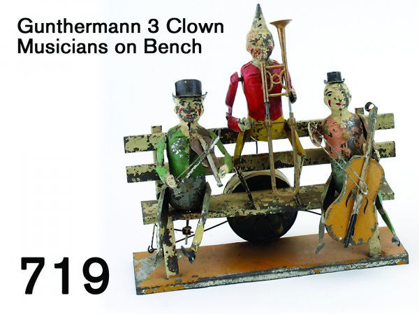 Gunthermann 3 Clown Musicians on Bench: Gunthermann 3 Clown Musicians on Bench painted tin clown figures seated on a bench, activated by clockwork mechanism on back which causes stringed instrument players to bow their instruments and tromb