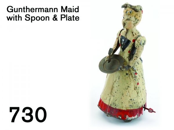 Gunthermann Maid with Spoon & Plate: Gunthermann Maid with Spoon & Plate painted tin with clockwork, great for: she wears apron and bow on hair and raises hands holding tin spoon and plate 7.5" t.