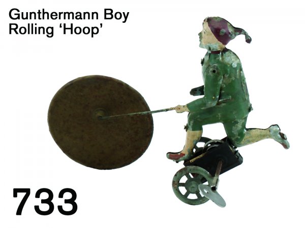 Gunthermann Boy Rolling 'Hoop': Gunthermann Boy Rolling 'Hoop' painted tin with clockwork, boy runs while pushing solid tin wheel 8" l.