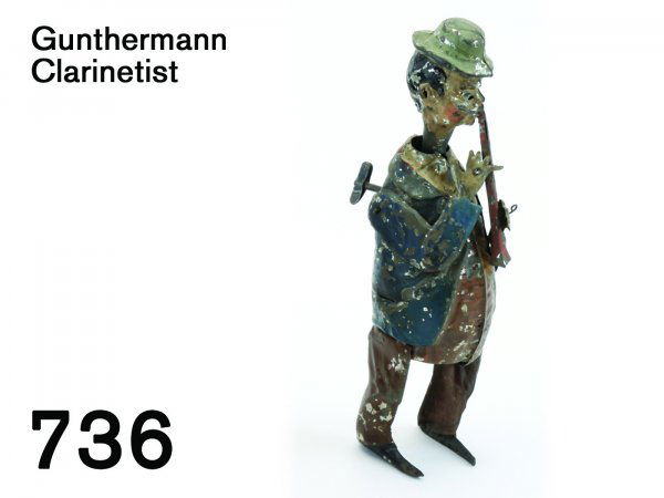 Gunthermann Clarinetist: Gunthermann Clarinetist painted tin with clockwork, as man plays he bobs head, arms, and horn up and down, internal bellows provides whistling noise 8" t.