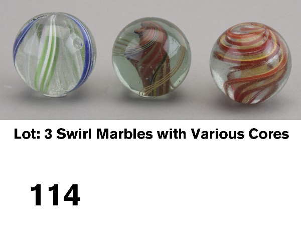 Lot: 3 Swirl Marbles with Various Cores: circa 1880-1900, German glass marbles include a 1 7/16" yellow latticinio core with outer ribbons of red, yellow, white and some orange pulled together making swirl from pontil to pontil (polished pon