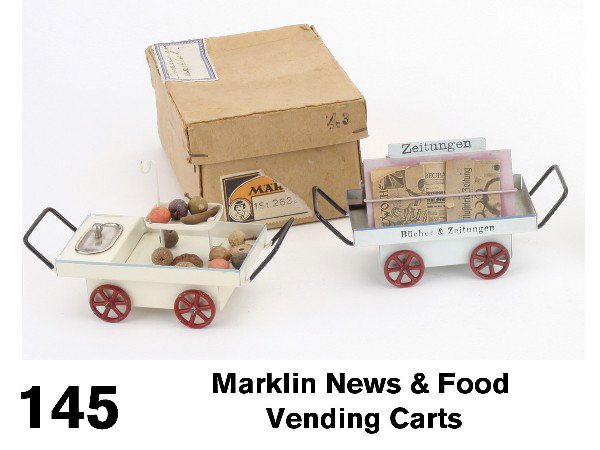 Marklin News & Food Vending Carts: hand enameled train accessory grouping includes food vending cart with small composition fruits with original box and news cart in German signage, both with maker's stamp on undersides Size: 4.5" l. e