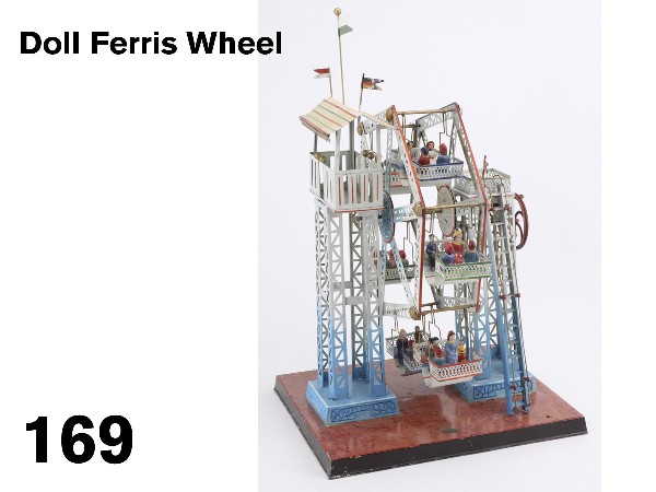 Doll Ferris Wheel: Germany, painted tin, hand operated crank or powered by steam engine, elaborate girder structure with ladder, canopy covered loading area, 6 hanging gondolas, 24 composition figures, a beautifully des