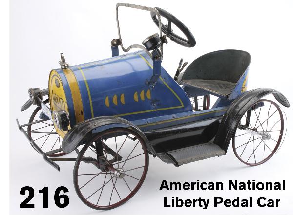 American National Liberty Pedal Car: painted wood and pressed steel with rubber tired wire spoked wheels, a well above average example of an early 1920's pedal car with original headlamps, license plate, wind shield, and lithographed tin