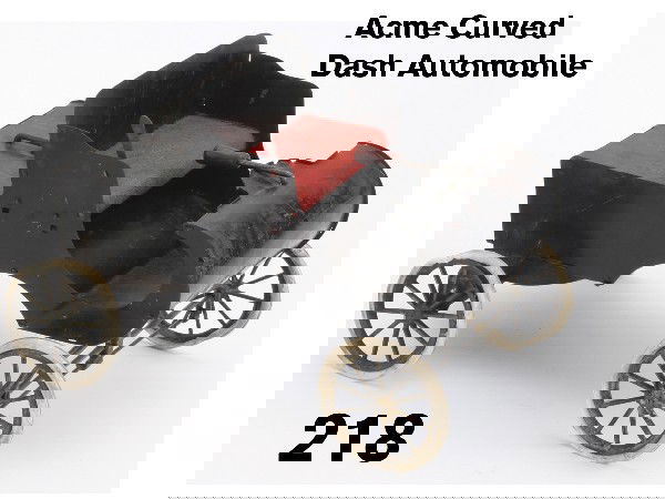 Acme Curved Dash Automobile: painted tin, with clockwork mechanism, cloth upholstered seat, tiller operated steering and operating hand brake Size: 10.5" l. x 7.25" t.