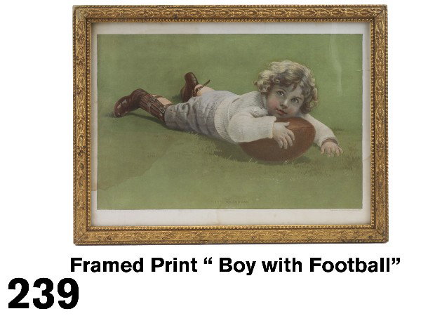 Framed Print " Boy with Football": circa 1907, chromolithographed print of young boy dressed in heavy sweater and football gear resting on a football. Print is titled "First Touchdown", supplement to The Christmas Globe 1907, Toronto L