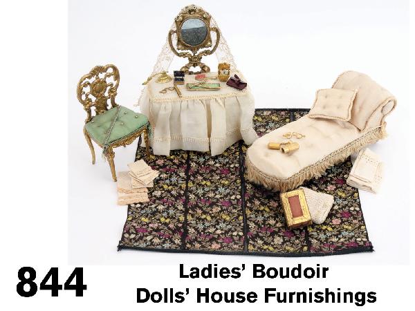 Ladies' Boudoir Dolls' House Furnishings: grouping includes Schneegas chaise lounge upholstered in cream tufted silk, dressing stand with mirror draped in lace; the ornate ormolu table is skirted in stiff crinoline with side chair upholstered