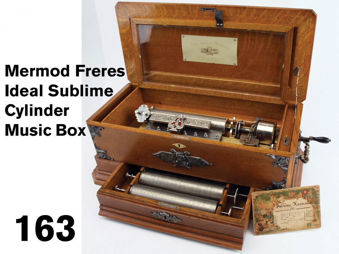 Mermod Freres Ideal Sublime Cylinder Music Box: Swiss cylinder music box circa late 19th century; lift top music box with crank handle on side, retains celluloid label with name and cherub with horns insignia on underside of lid. This complex cylin