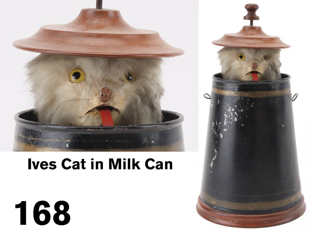 Ives Cat in Milk Can: the painted tin can is on a wooden base and has a wooden lid, when the internal clockwork mechanism is activated the lid rises - pushed open by a glass eyed fur covered cat who turns his head while st