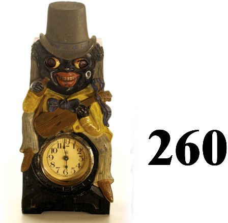 Gray Hat Minstrel Moving Eye Clock: Gray Hat Minstrel Moving Eye Clock cast metal face plate with wooden back, made in Germany, beveled glass clock cover, eyes go back and forth when working, strong caricature image of dandified guitar