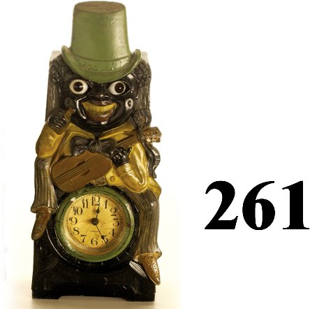 Green Hat Minstrel Moving Eye Clock: Green Hat Minstrel Moving Eye Clock cast metal face plate with wooden back, made in Germany, beveled glass clock cover, eyes go back and forth (1 not moving), strong caricature image of dandified guit