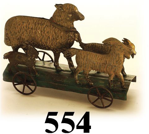 American Tin Lambs and Goats Platform To: American Tin Lambs and Goats Platform Toy painted tin with cast iron wheels, great form - 1 large lamb and 3 goats of various sizes 9" l. fair to good (serious paint loss overall)