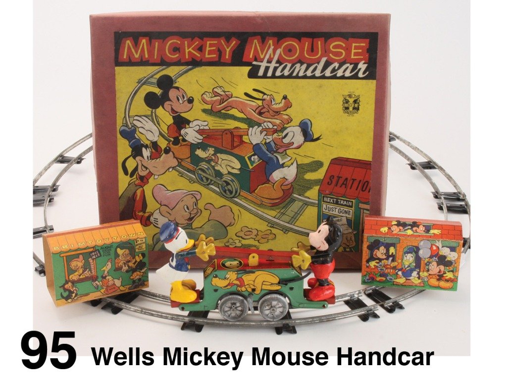 Wells Mickey Mouse Handcar: lithographed tin clockwork handcar with painted composition Mickey Mouse and Donald Duck in colorful lithographed box with track and 2 cardboard buildings Size: box 13.75" x 12.25", car 8" l.