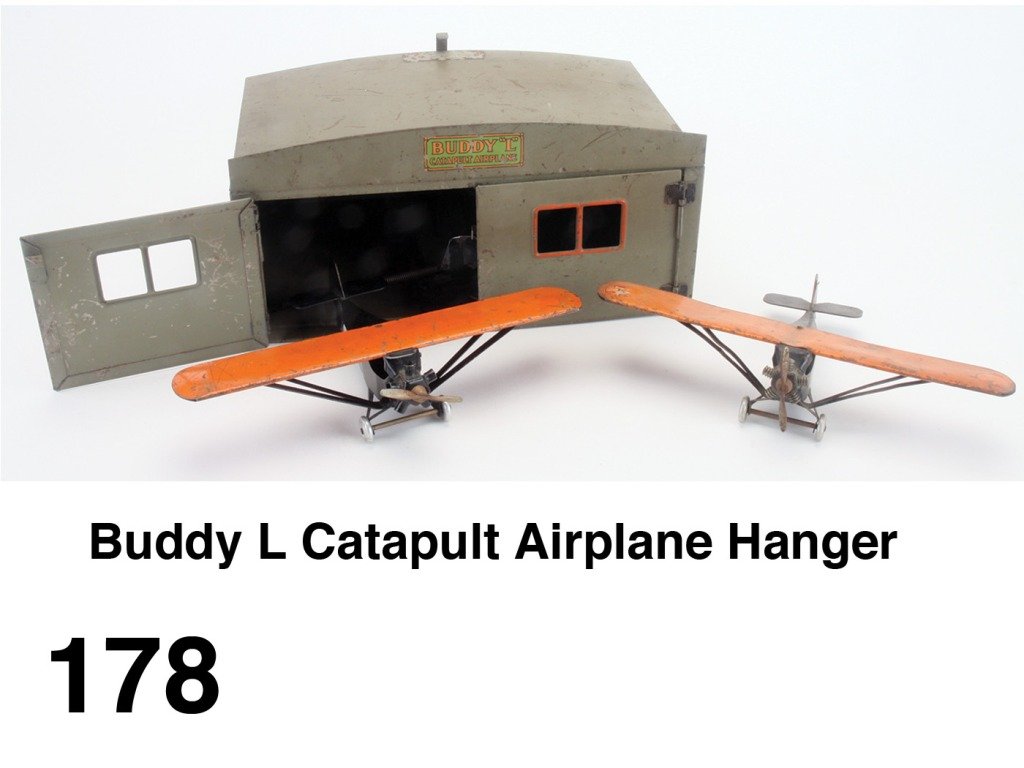 Buddy L Catapult Airplane Hanger: painted pressed steel hanger with spring loading catapult and offered with 2 monocoupe planes Size: hanger 12" w. x 6" t. x 8" d.