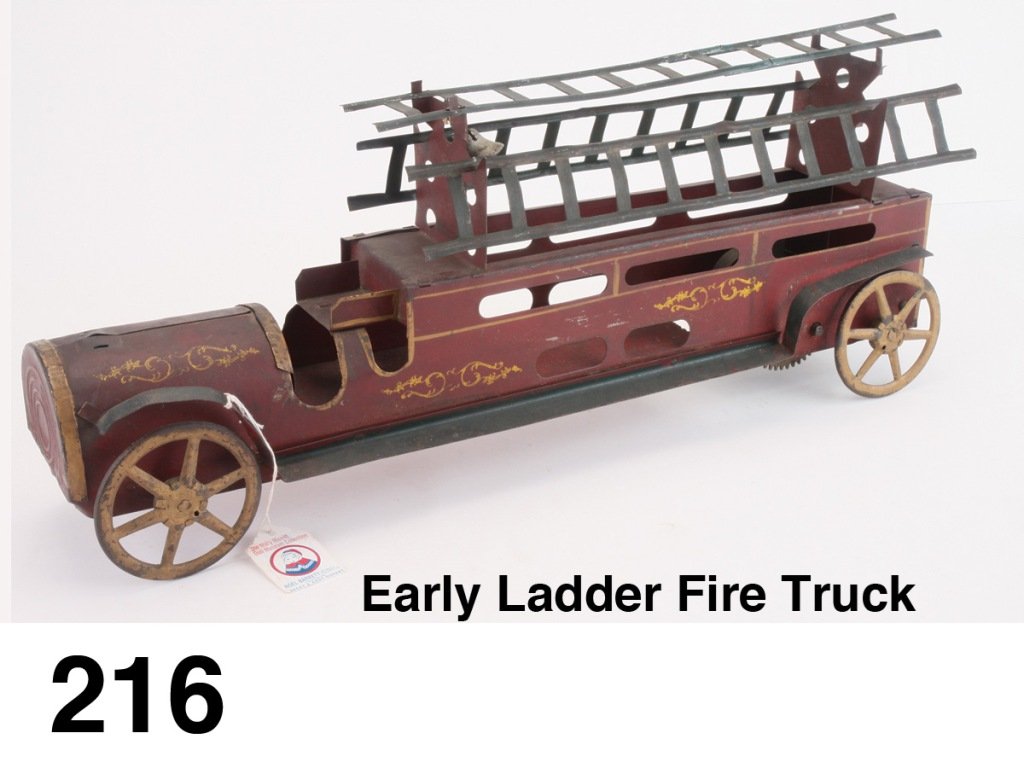 Early Ladder Fire Truck: painted tin and wood with stencil decorations, unusual spring powered action: rolling the toy backwards tightens the spring which then propels the toy forward - impressive scale; has been attributed t