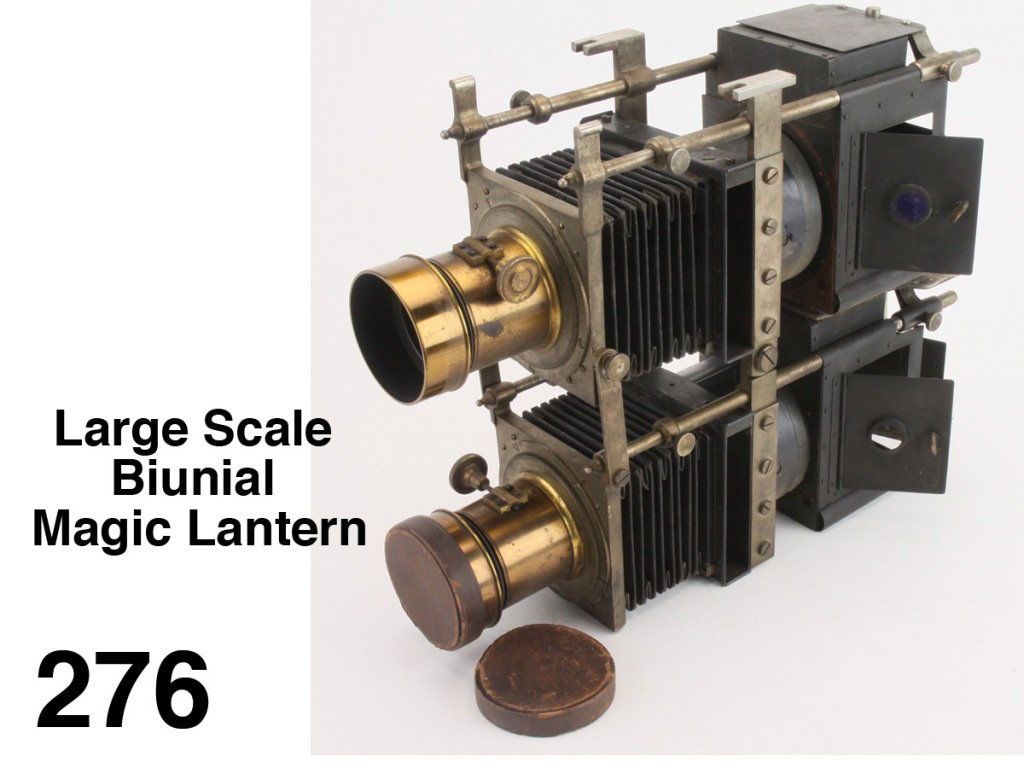 Large Scale Biunial Magic Lantern: a Biunial projector with brass mounted lenses with leather lens caps, worm gear focusing and cloth bellow extensions appear fully functional- illumination chambers are empty Size: 15" t., 16" l. as pi
