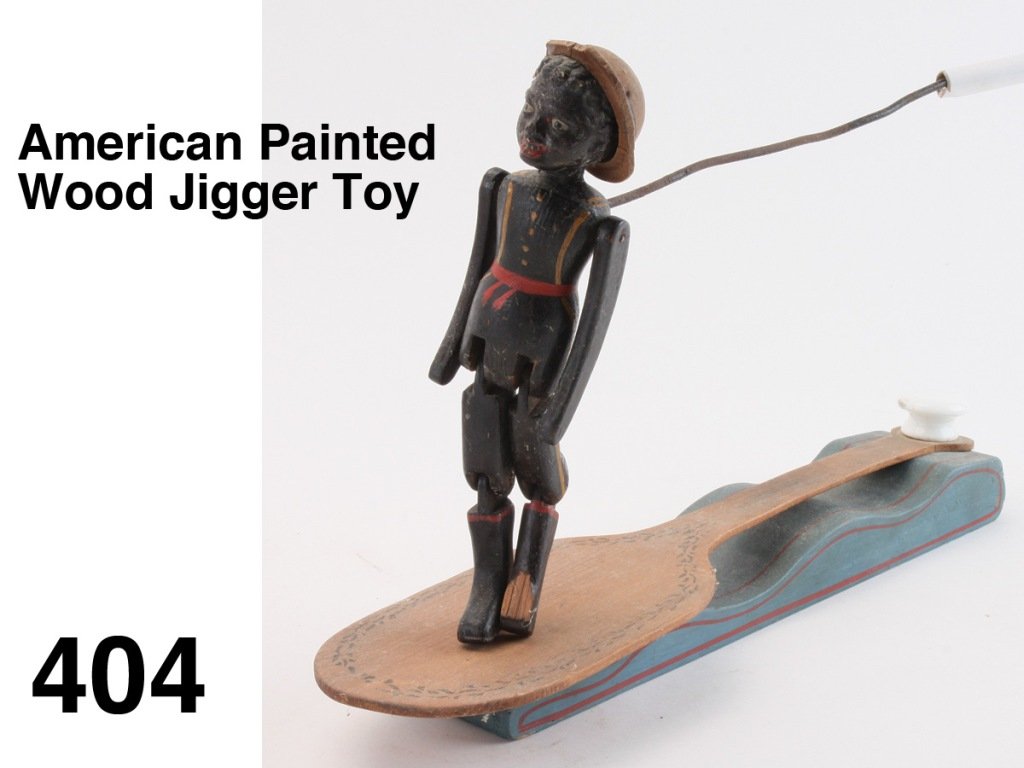 American Painted Wood Jigger Toy: figure in the form of black boy with jointed shoulders, hips and knees; held with wire he dances on a stenciled paddle and blue base with red striping, with with stenciled patent date of December, 186