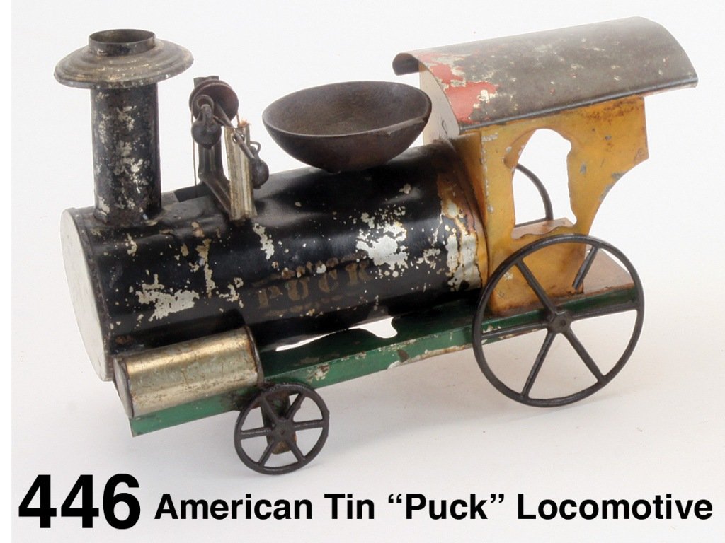 American Tin 'Puck' Locomotive: painted and stenciled tin with cast iron wheels and front axle driven pulley system to ring cast iron boiler mounted bell, fairly strong lettering 'Puck' on sides, attributed to Althof-Bergmann Size: 