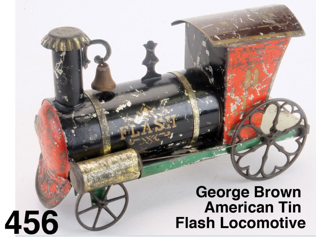 George Brown American Tin Flash Locomotive: painted tin with cast iron wheels, heart motif on large rear wheels, retains strongly stenciled name 'Flash' on boiler side, cow catcher has embossed hearts Size: 10.5" l.