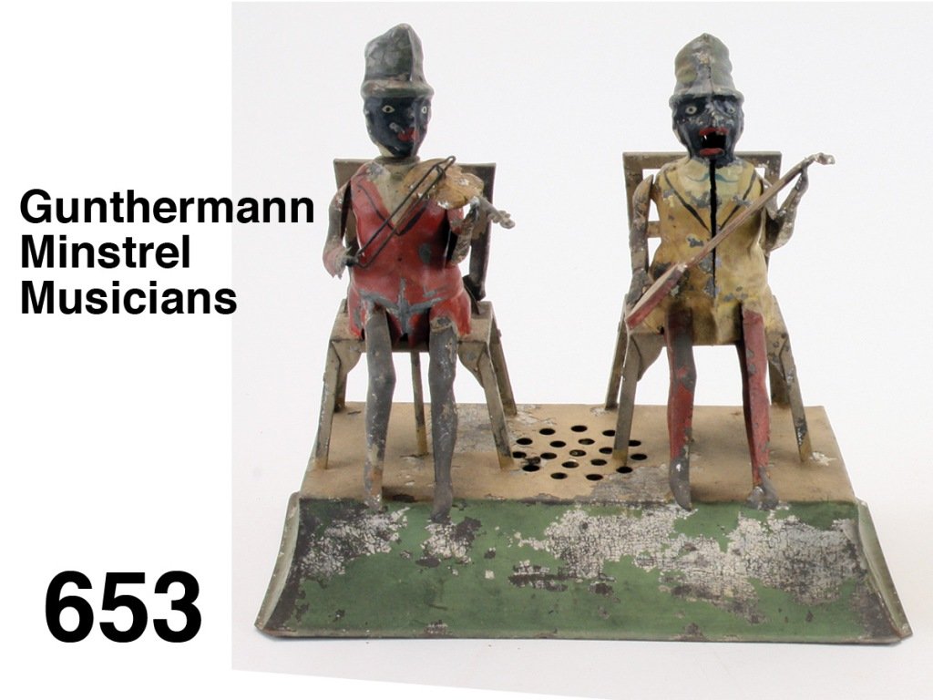 Gunthermann Minstrel Musicians: painted tin clockwork with plink plunk music, complex action: violinist turns head as he bows while banjo player opens and closes mouth while strumming Size: 8.5" w., 8" t.