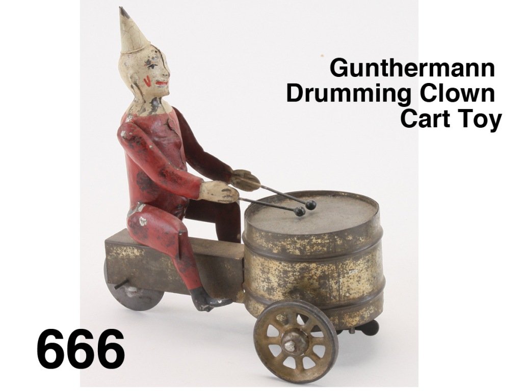 Gunthermann Drumming Clown Cart Toy: painted tin with clockwork mechanism in drum, figure drums as 3 wheel cart proceeds Size: 6" l.