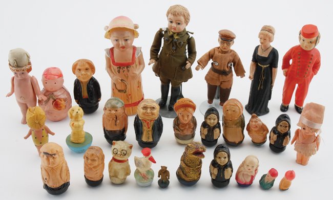 Celluloid Dolls & Rollys: 20 weighted rolly-polys in various animal and human forms, a two faced rattle with tilting hat that reveals happy face or frowning face, 2 cloth dressed chauffeur/military figures, a bellhop, a lady i