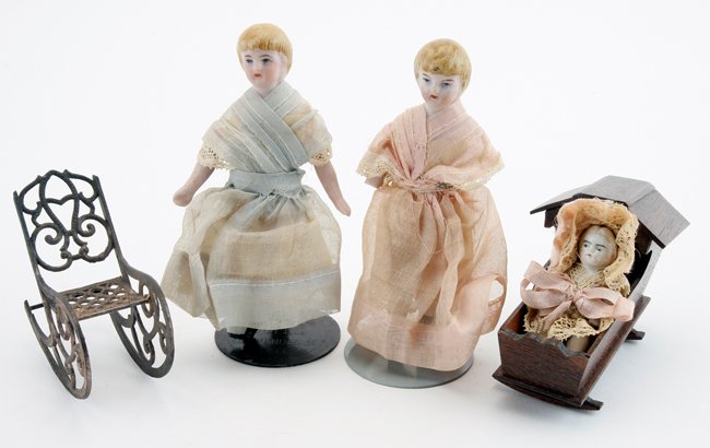 Two Dolls with Cradle: painted bisque with molded hair in matching early gauze dresses with soft metal rocker and finely crafted English cradle with jointed porcelain baby in lace outfit 4.5" t.